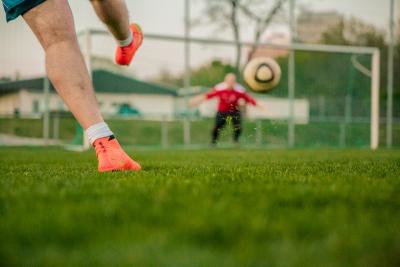 jogador de futebol chuta bola