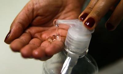 mulher aplica álcool gel nas mãos