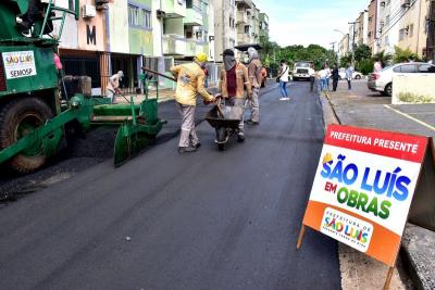 homens trabalham em asfaltamento de rua