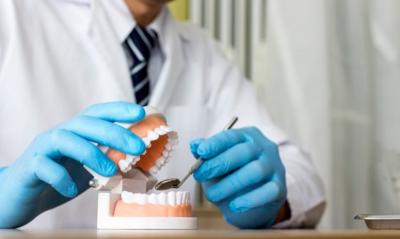 dentista analisa prótese dentária