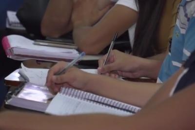 estudantes escrevem em caderno