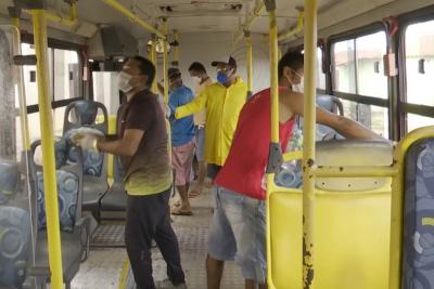 homens higienizam interior de ônibus
