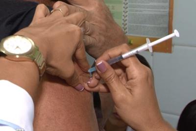 agente de saúde aplica vacina